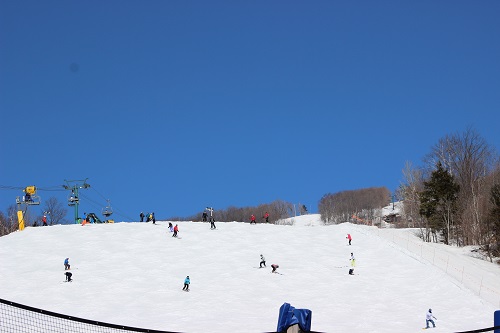 White hill with skiers finishing slope