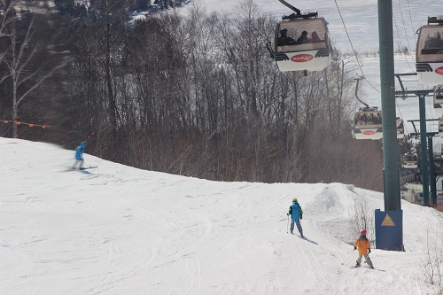 Skiers under lift cabin